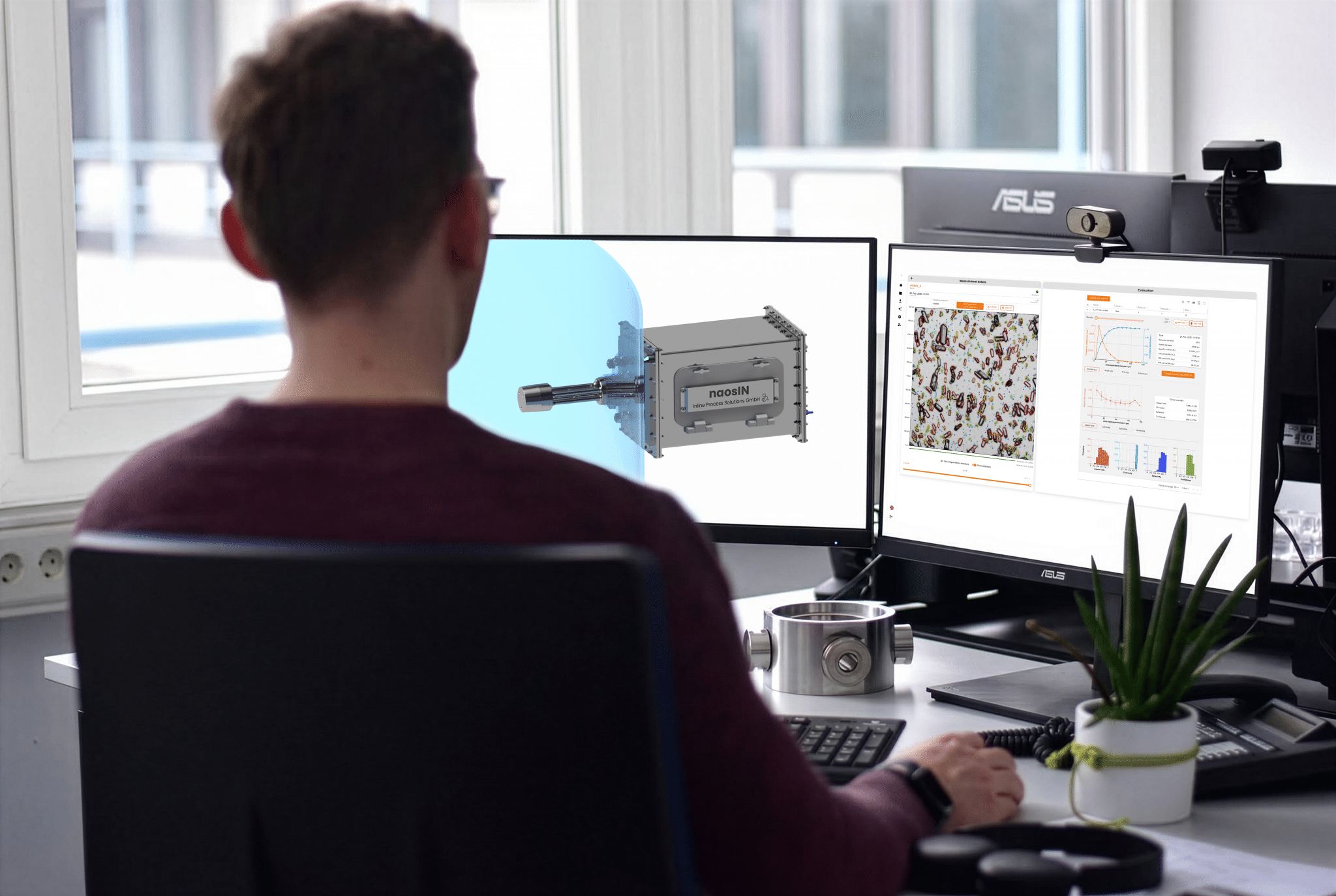 Mann sitzt vor zwei Bildschirmen.